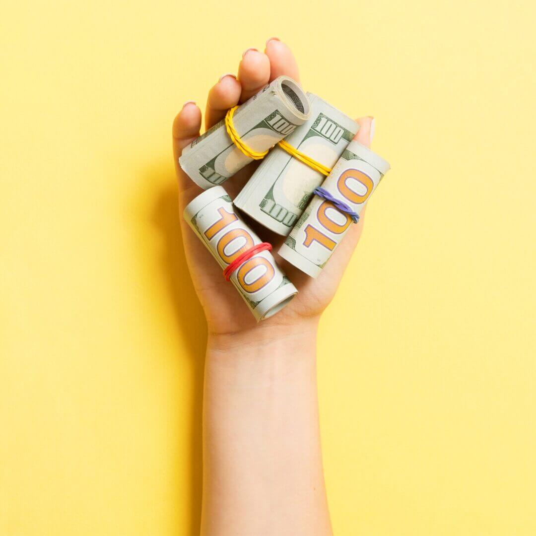 A hand with $100 dollar bills