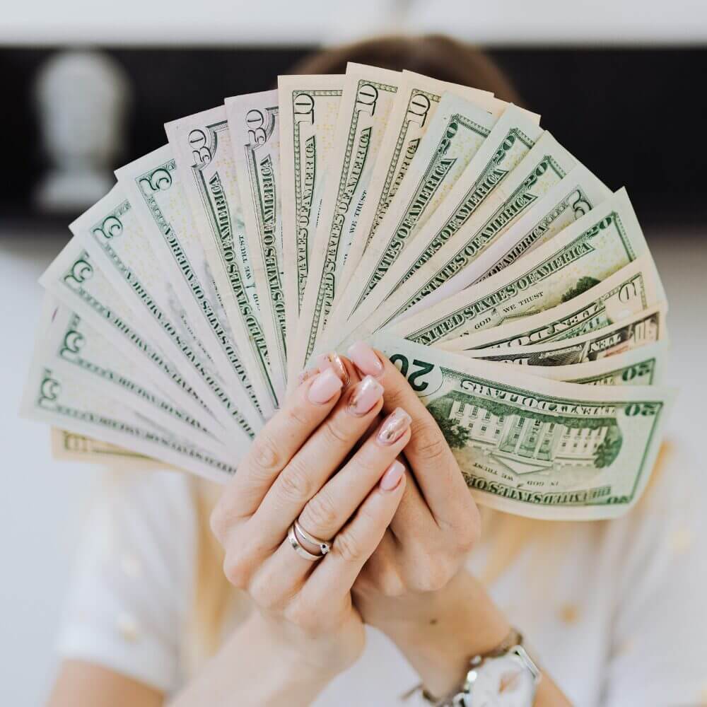 A lady fanning a large wad of cash