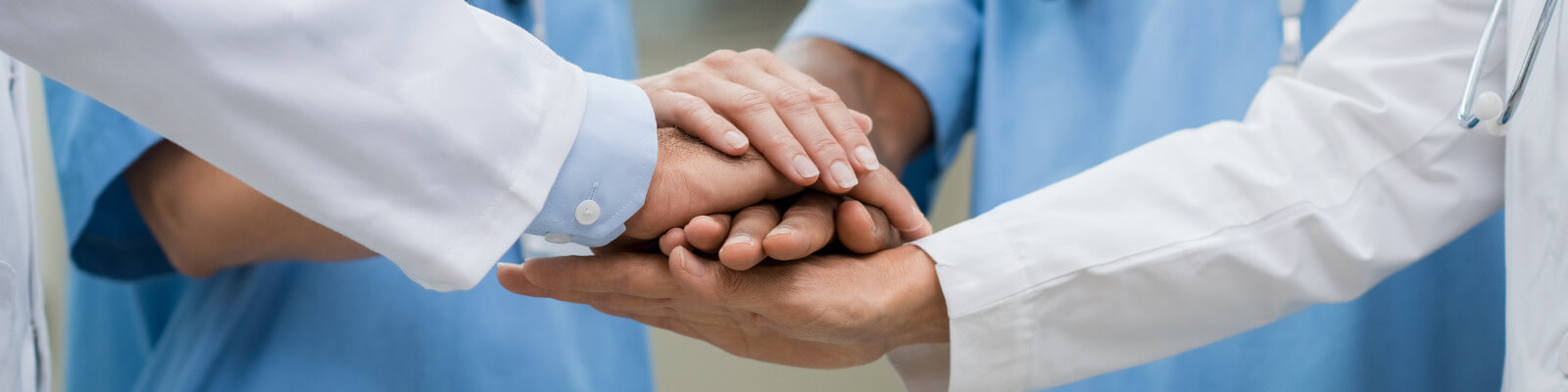 Medical professionals put their hands together in solidarity