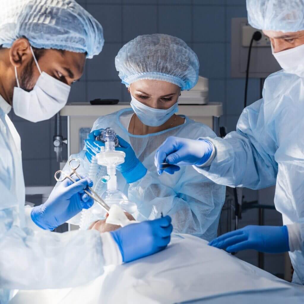 Three healthcare providers, one CRNA, administer anesthesia to a patient